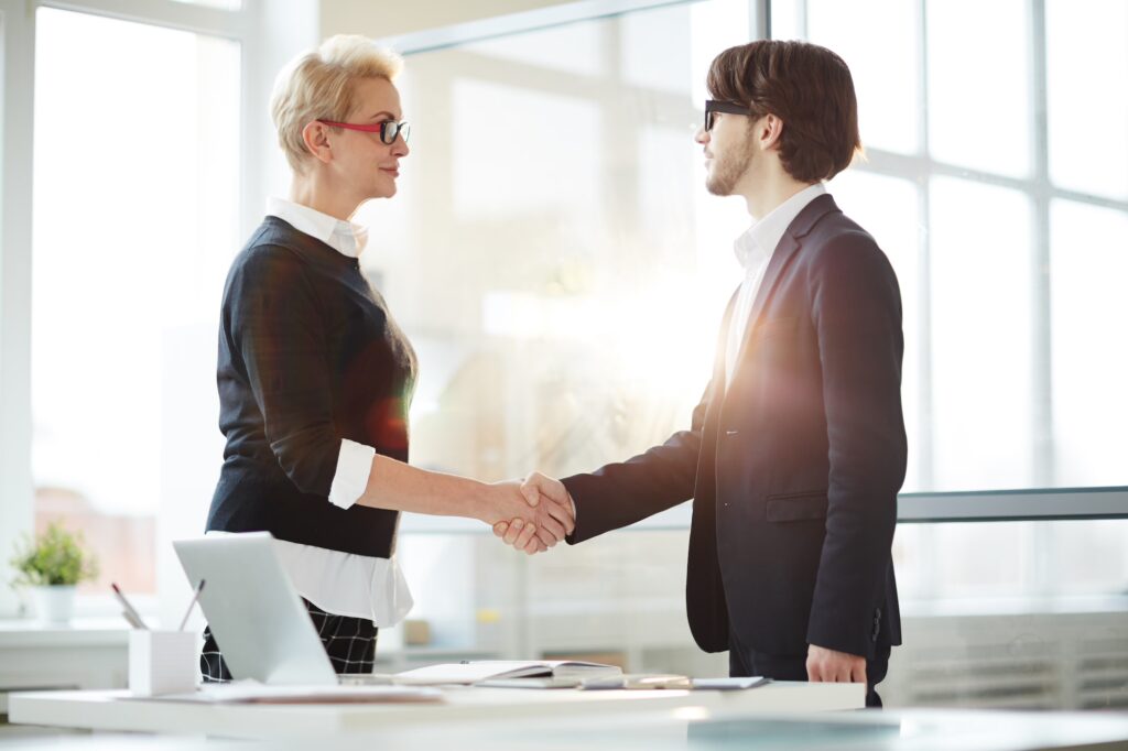 Zwei Menschen schütteln Hände wie im Business